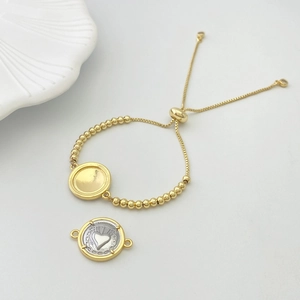 Close-up of adjustable gold bead bracelet with dual-tone heart charm and religious medals
