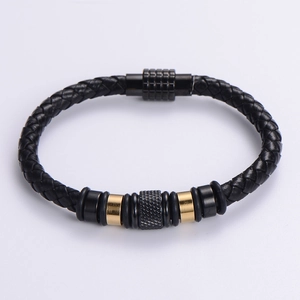 Detail of woven black leather bracelet with gold metal rings and magnetic clasp