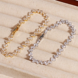 Detailed macro view of gold and silver bracelets featuring marquise-cut cubic zirconia