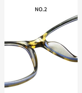 Macro shot of tortoise shell eyeglass frame featuring integrated nose pads and acetate texture