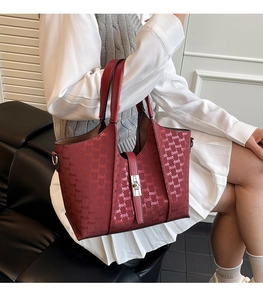 Detail view of burgundy PU leather tote bag with embossed pattern and metal clasp