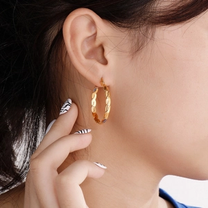 Detailed close-up of a 4mm gold twisted hoop earring worn by a model for fashion style