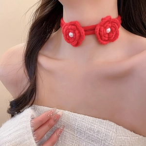 Detail of red knitted floral choker featuring white pearls on handmade rose neckband