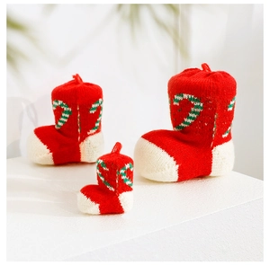 Three sizes of knitted Christmas stocking boots with candy cane pattern for decor