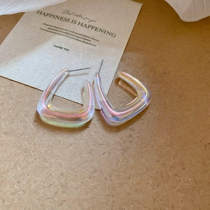 Detail of iridescent acrylic C-shape earrings with a holographic laser finish