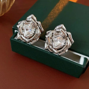Macro de boucles d'oreilles rose en argent avec diamants sur boîte verte