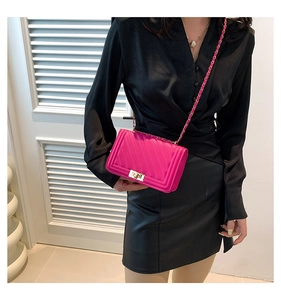 Close-up of pink crossbody bag with chevron quilting and golden metal twist lock