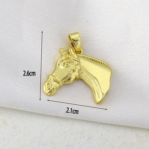 Macro shot of gold horse head pendant with dimensions 2.6cm by 2.1cm on silk background
