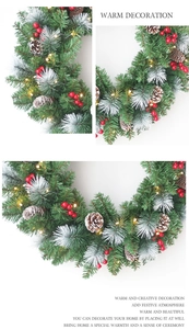 Close-up of Christmas wreath with pine needles, red berries, cones and warm LED lights
