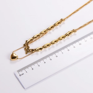 Close-up of golden layered heart pendant chain with ruler measurement in centimeters