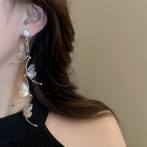 Close-up of elegant silver drop earrings with hollow butterfly charms and rhinestones