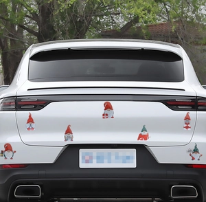 Detailed view of colorful Christmas gnome magnetic stickers on a white SUV rear