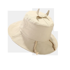 Detail view of beige canvas bucket hat featuring decorative horn accents and adjustable cords
