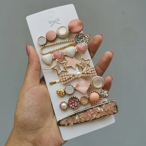 Detailed close-up of 8-piece hair clip set with pearls and pink star charms