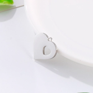 Minimalist heart-shaped hollow pendant in silver stainless steel on a white surface