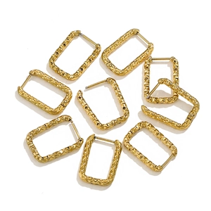 Detailed close-up of rectangular gold titanium earrings with stylish hammered texture finish