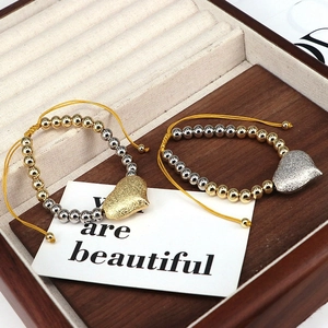 Detail of adjustable heart charm bracelets in gold and silver finish with gift card