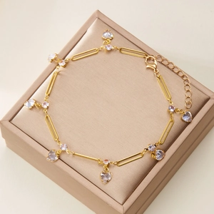 Detailed shot of golden paperclip chain bracelet with heart pendants in a gift box