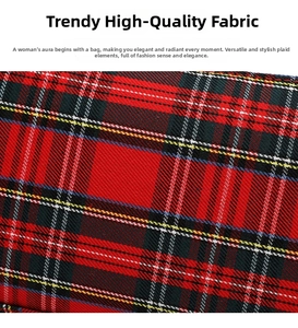 Close-up of red plaid fabric texture with precise stitching on a vintage baguette bag
