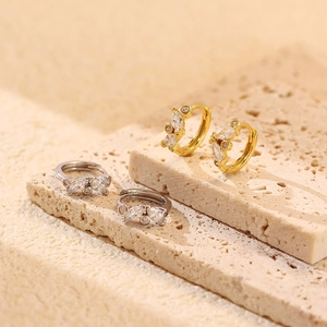 Close-up of gold and silver hoop earrings featuring marquise-cut marquise zircon clusters