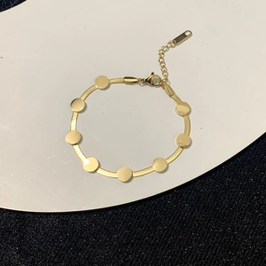 Close-up of gold snake chain necklace with smooth round sequins and lobster clasp