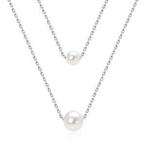 Detailed macro view of the layered silver chain and round white pearl pendant necklace
