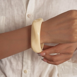 Vue détaillée d'un bracelet en acrylique crème avec facettes géométriques pour femmes