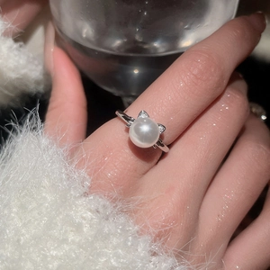 Close-up of pearl ring featuring silver cat ear design with small sparkling diamonds