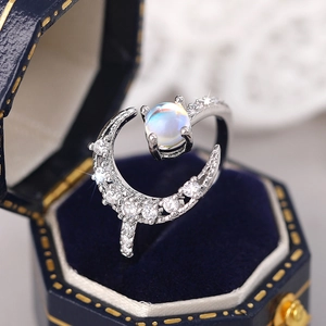 Macro shot of silver moon ring with pave stones and glowing moonstone in velvet box