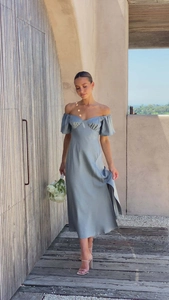 Détail d'une robe midi en satin gris-bleu avec fente latérale élégante et col bardot