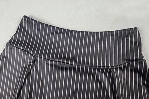Detail of waist design and striped pattern on black and white vertical stripe skirt