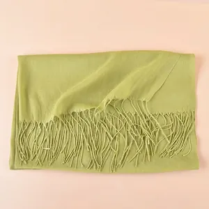 Detail of light green pashmina scarf featuring micro-wrinkle texture and soft tassel fringe