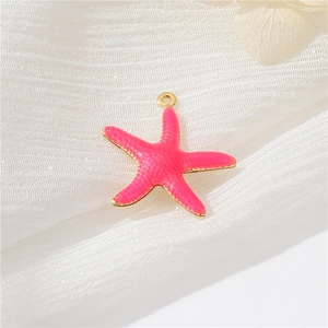 Macro view of a pink starfish pendant with gold-plated edges for DIY jewelry making