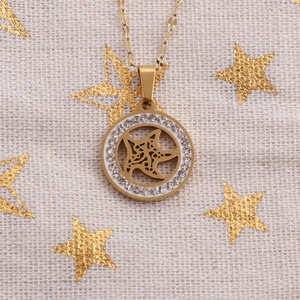 Close-up of golden necklace pendant with sparkling rhinestones and hollow star design