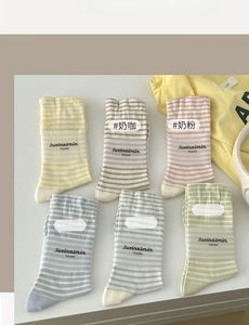 Detail of striped crew socks in six pastel colors like yellow and blue with cotton texture