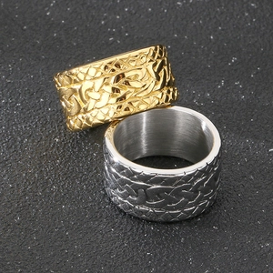 Detailed view of woven texture on gold and silver stainless steel rings on rock surface