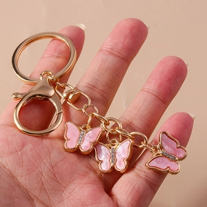 Detail of pink butterfly keychain featuring gold finish and sparkling crystal accents