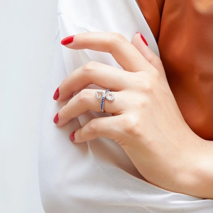 Detail of S925 silver ring featuring blue heart-shaped zircons on woman's hand