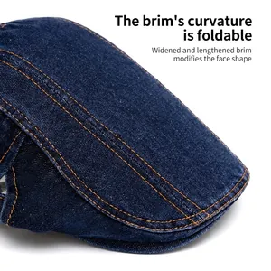 Washed dark blue denim newsboy cap with orange stitching and foldable wide brim
