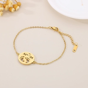 Detailed view of golden MOM bracelet with baby footprints charm on light background