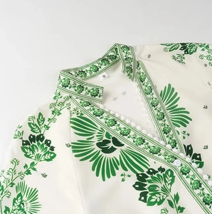Close-up of V-neckline detail with single-breasted buttons on green floral maxi dress
