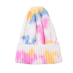 Detail of colorful tie-dye knit beanie showing chunky cable knit texture and folded cuff