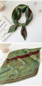 Detailed view of dark green pleated scarf with vintage patterns and fine accordion folds