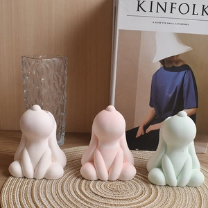 Three cute silicone puppy molds in white, pink, and mint green on a rustic wooden background