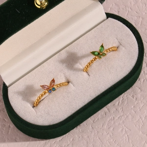 Detailaufnahme von verstellbaren Schmetterlingsringen mit bunten Edelsteinen in Schmuckbox
