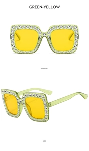 Detail view of oversized square green sunglasses with yellow lenses and rhinestones