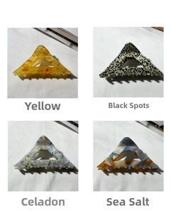 Detail showing four acetate hair claw clips in amber, polka dot, floral, and sea salt patterns