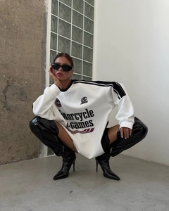 Detail of oversized graphic sweatshirt with motorcycle games print and patent leather boots