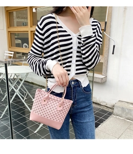 Pink printed handbag with geometric patterns shown on model during an outdoor street shoot