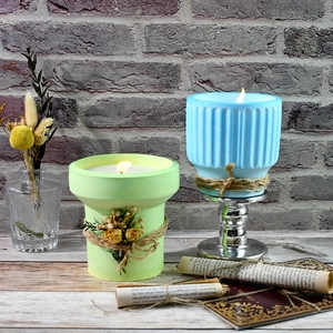 Macro detail of striped blue and green plaster candle jars with dried flowers and twine
